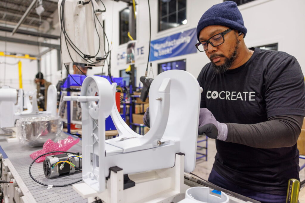 A CoFab Artisan building a GE Profile Smart Stand Mixer on the customizable CoFab assembly line.